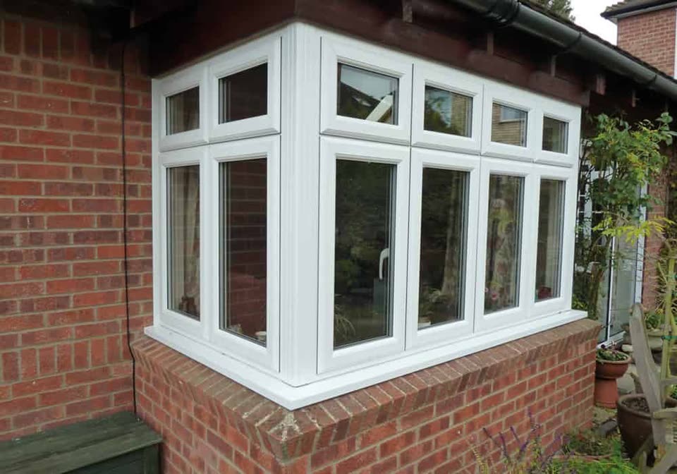 White uPVC casement windows on the corner of a brick house